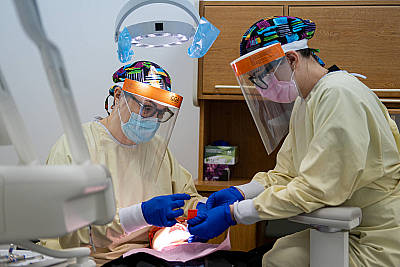 Natalia Registered Restorative Dental Hygienist and Marichka RDA during COVID-19 time treating patient in specialised operatory equipped with negative pressure unit and HEPA filters